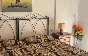 a bedroom with a bed with a black and yellow comforter at Cozy Apartment In Los Alcazares With Wifi in Los Alcázares