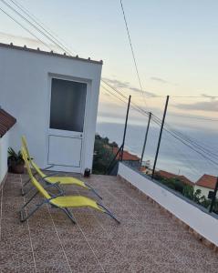 a yellow chair sitting on top of a balcony at Cozy 1 BR w/ balcony, ocean view & perfect sunsets in Ribeira Brava