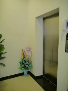 a vase of flowers sitting next to a elevator at Hotel Wawasan in Simpang Renggam