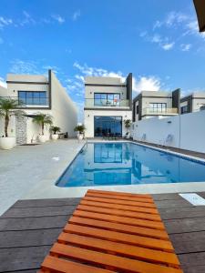 a house with a swimming pool in front of it at Iconic 4-bedroom villa with pool in Fujairah Palm in Fujairah