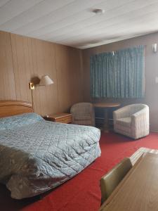 une chambre d'hôtel avec un lit et une table dans l'établissement Sunset Motel, à Schreiber