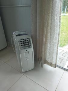 a heater sitting on the floor next to a window at Kitbox PDR in Garopaba