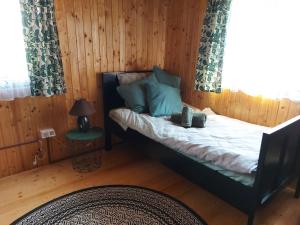 ein kleines Schlafzimmer mit einem Bett und einem Fenster in der Unterkunft Drvena kuca za odmor Cvetkovic brdo 