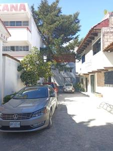 ein Auto, das auf einem Parkplatz neben einem Gebäude parkt in der Unterkunft Suite Villa Real in San Cristóbal de las Casas
