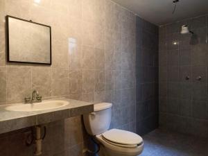 ein Badezimmer mit einem WC, einem Waschbecken und einem Spiegel in der Unterkunft Suite Villa Real in San Cristóbal de las Casas