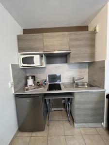 a small kitchen with a sink and a microwave at Studio Meublé in Bussy-Saint-Georges