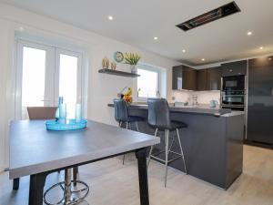 uma cozinha com mesa e cadeiras num quarto em Palm View em Newquay