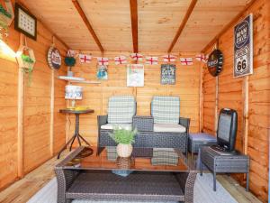 uma cabana com duas cadeiras, uma mesa e uma televisão em Palm View em Newquay