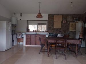 cocina con mesa, sillas y nevera en Loft on Los Reartes River, Intiyaco en Villa Berna