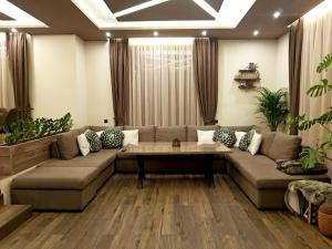 uma sala de estar com um sofá e uma mesa em Къща за гости Амая - Сандански em Sandanski