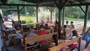a group of people sitting on benches in a pavilion at Penzion Kairos in Klokočí