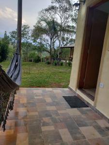 a porch with a hammock next to a door at Chalézinho da Montanha - Sítio Pasangas in Santo Antônio do Pinhal