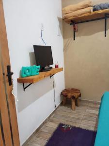 a room with a computer monitor on a shelf on a wall at Chalézinho da Montanha - Sítio Pasangas in Santo Antônio do Pinhal
