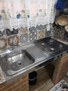 cocina con fregadero y fogones en Chalézinho da Montanha - Sítio Pasangas, en Santo Antônio do Pinhal