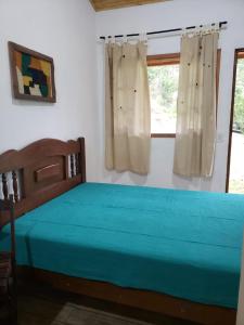 1 dormitorio con cama y ventana en Chalézinho da Montanha - Sítio Pasangas, en Santo Antônio do Pinhal