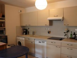 eine Küche mit weißen Schränken und einem Geschirrspüler in der Unterkunft Appartement climatisé avec 2 chambres, terrasse et garage à Cavalaire-sur-Mer - FR-1-100-218 in Cavalaire-sur-Mer