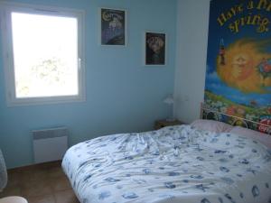 ein Schlafzimmer mit einem Bett und einem Plakat an der Wand in der Unterkunft Appartement Cavalaire-sur-Mer, 3 pièces, 6 personnes - FR-1-100-212 in Cavalaire-sur-Mer