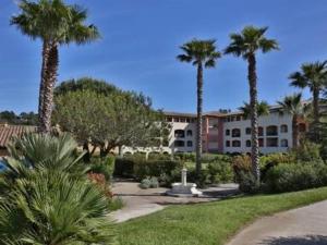 ein Resort mit Palmen und einem Gebäude in der Unterkunft Appartement Cavalaire-sur-Mer, 3 pièces, 6 personnes - FR-1-100-212 in Cavalaire-sur-Mer