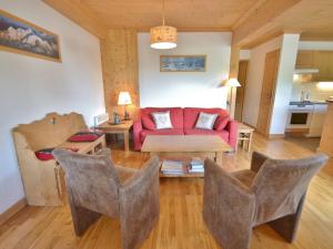 sala de estar con sofá rojo y sillas en Appartement Le Grand-Bornand, 4 pièces, 6 personnes - FR-1-391-108, en Le Grand-Bornand