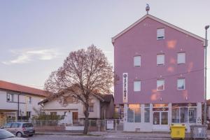 a purple building with a tree in front of it at AS APARTMANI PIROT in Pirot