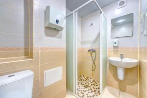 uma casa de banho com um chuveiro, um WC e um lavatório. em Hotel 7F em Kiev
