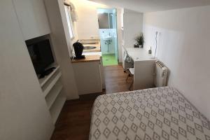 Habitación pequeña con cocina y 1 cama en una habitación. en Acogedor Estudio Céntrico en Santiago de Compostela