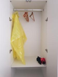 a shelf with a yellow plastic bag and hangers at Acogedor Estudio Céntrico in Santiago de Compostela
