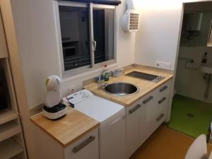 una pequeña cocina con fregadero y ventana en Acogedor Estudio Céntrico en Santiago de Compostela