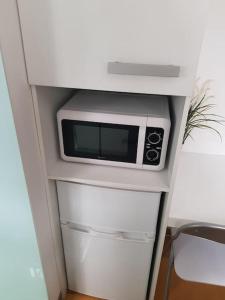 a microwave sitting on top of a white cabinet at Acogedor Estudio Céntrico in Santiago de Compostela