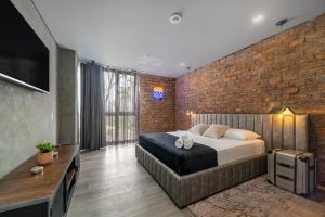 - une chambre avec un lit et un mur en briques dans l'établissement Olive Living Suites by HOUSY HOST, à Envigado