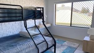 a bunk bed in a room with a window at Flinders Lodge unit 9 in Yamba
