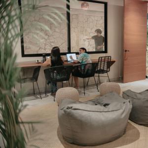 two people sitting at a table with a laptop at Khali Cancún in Cancún