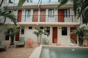 a house with chairs and a pool in front of it at Khali Cancún in Cancún