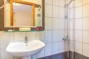 a bathroom with a sink and a mirror at Verginarooms in Nea Potidaea