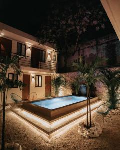 una piscina en medio de una casa por la noche en Khali Cancún en Cancún