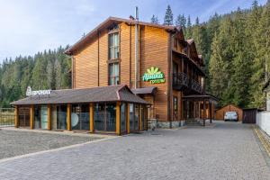 a large wooden building on the side of a road at Arnika Hotel in Bukovel