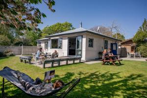 a woman laying in a hammock in the yard of a house at Mountain View Backpackers in Wanaka