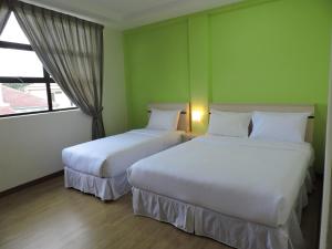 Postel nebo postele na pokoji v ubytování Merlin Hotel Penang