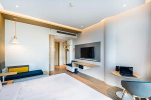 ein Wohnzimmer mit einem Sofa und einem TV in der Unterkunft Holiday Inn Express Shanghai Pudong Zhangjiang, an IHG Hotel in Shanghai