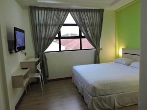Postel nebo postele na pokoji v ubytování Merlin Hotel Penang