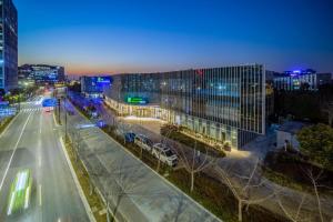 vista para uma rua da cidade à noite com edifícios em Holiday Inn Express Shanghai Pudong Zhangjiang, an IHG Hotel em Xangai