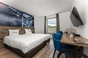 pokój hotelowy z łóżkiem i biurkiem z komputerem w obiekcie Velotel Brugge w Brugii