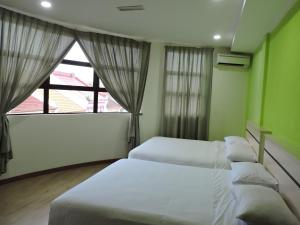 Postel nebo postele na pokoji v ubytování Merlin Hotel Penang