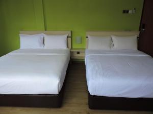 Postel nebo postele na pokoji v ubytování Merlin Hotel Penang