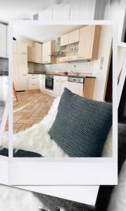 una cocina con armarios blancos y un sofá en una habitación en Appartamento Verena, en Dobbiaco