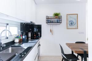 cocina con fregadero y mesa de madera en Feel Nazaré - Batalha 124, en Nazaré