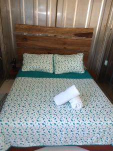 Una cama con dos rollos de papel higiénico. en Container House Cahuita en Cahuita