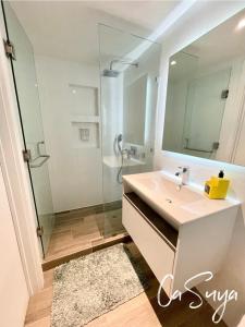 a bathroom with a sink and a shower with a mirror at CaSuya Airali apartments with heated pool, gym in city center in Guatemala