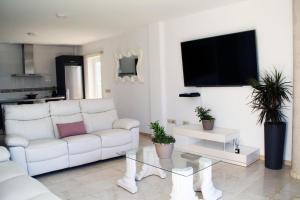 sala de estar con sofá blanco y TV en Villa Cristallo en Costa Adeje en Playa de las Americas