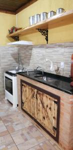 uma cozinha com um lavatório e um fogão em Casa Grande da Montanha - Sítio Pasangas em Santo Antônio do Pinhal